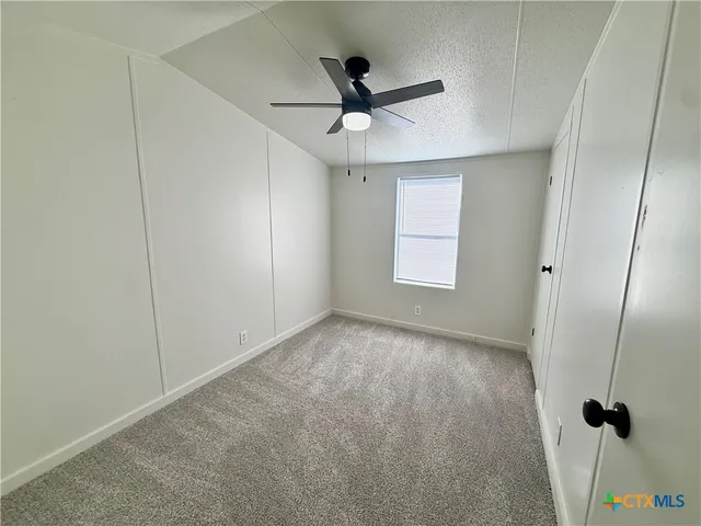 a view of empty room with ceiling fan