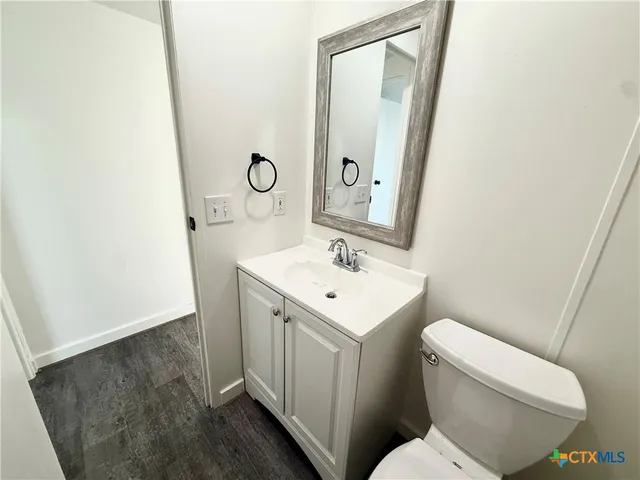a bathroom with a toilet sink and mirror