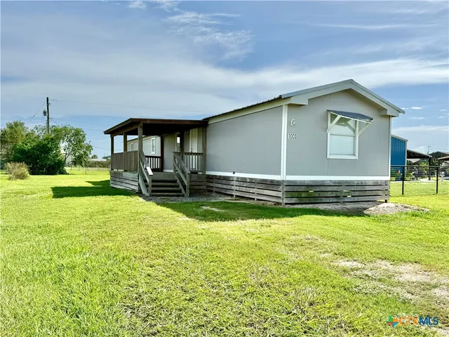 a view of a house with backyard and porch