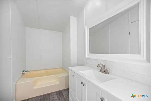 an empty room with a window and ceiling fan