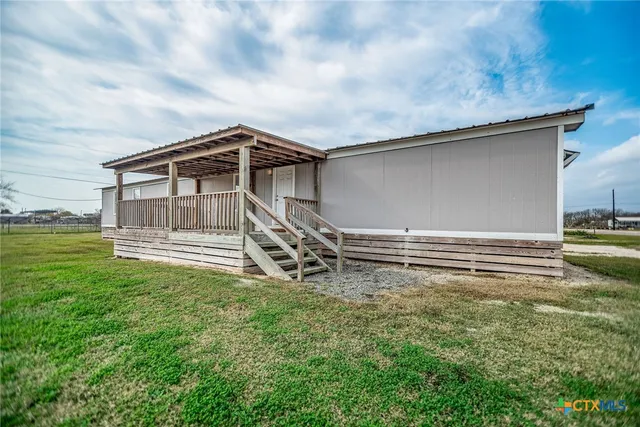 a view of a house with a small yard and wooden fence