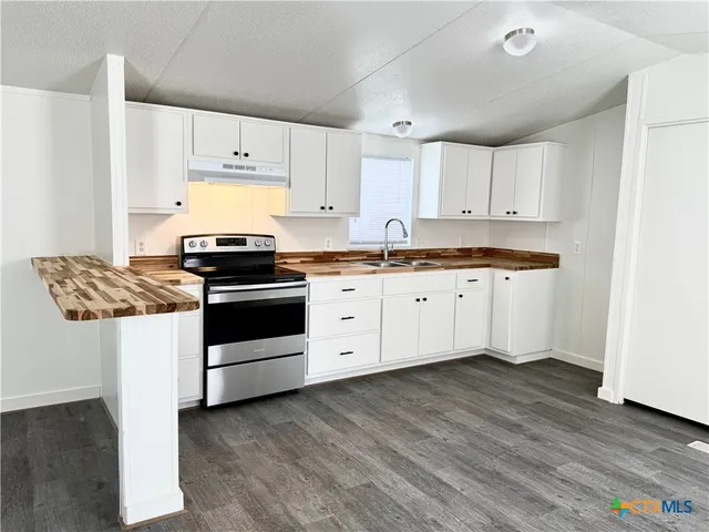 a kitchen with granite countertop white cabinets and white appliances