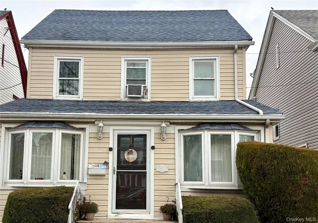 a front view of a house with a garden