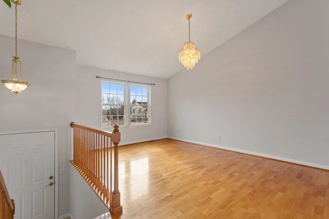 an empty room with windows and chandelier