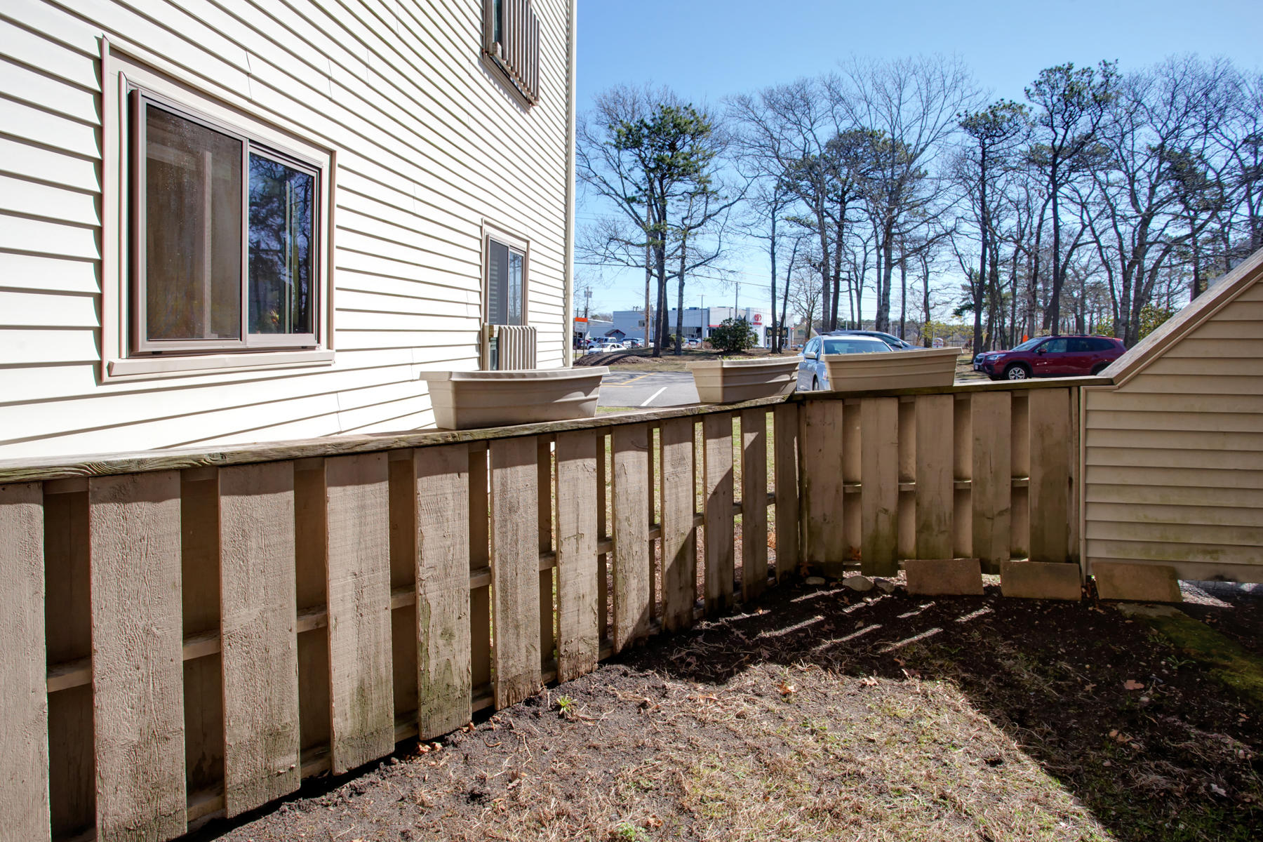800 Bearses Way, Unit 4EF Hyannis, MA 02601 - Photo 19 of 22 a view of backyard with large trees and wooden fence
