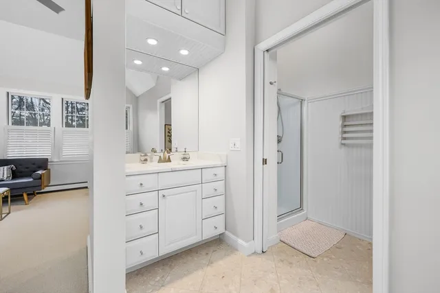 a spacious bathroom with a double vanity sink a mirror and a shower