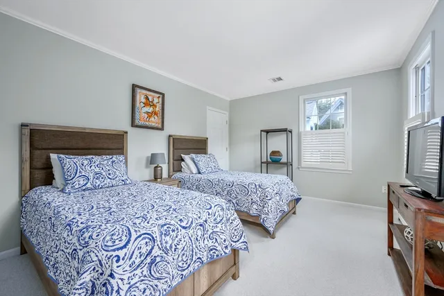 a bedroom with two beds and a flat screen tv