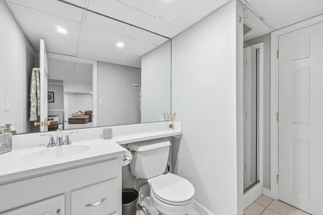 a bathroom with a toilet a sink a mirror and vanity