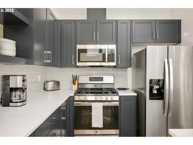 a kitchen with stainless steel appliances a stove a microwave a sink and cabinets