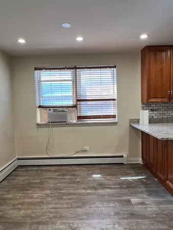 an empty room with wooden floor and window
