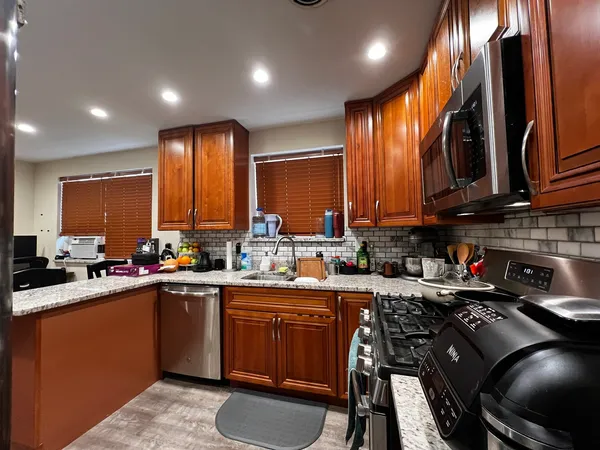 a kitchen with a sink a stove cabinets and a dining table