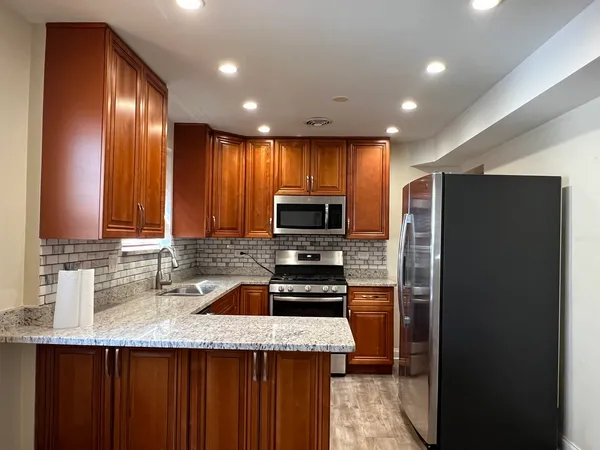 a kitchen with granite countertop stainless steel appliances a refrigerator and a sink