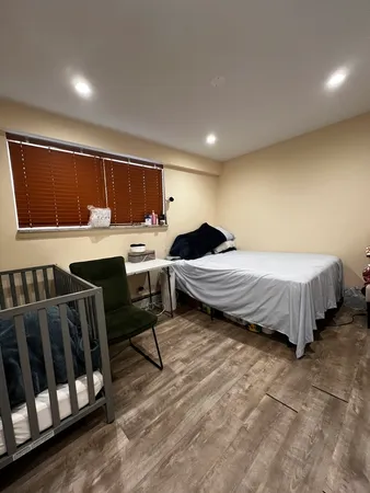 a bedroom with a bed and wooden floor