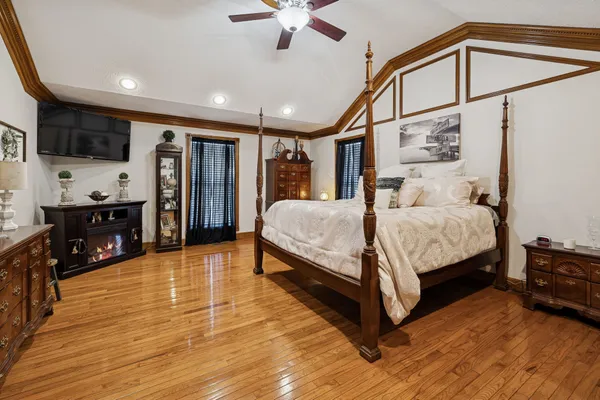 a bedroom with a bed window and a chandelier