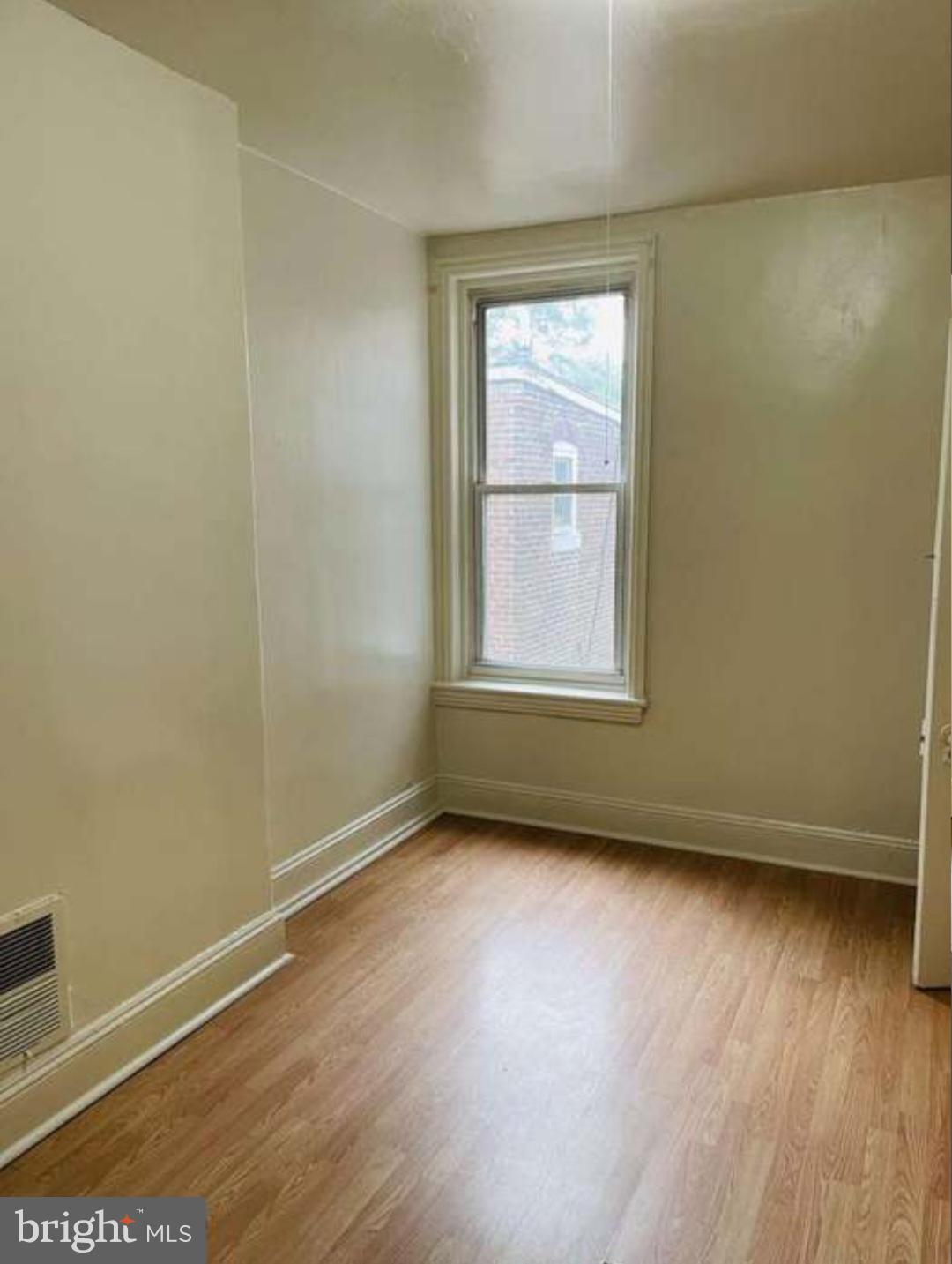 186 West Hanover Street Trenton, NJ 08618 - Photo 3 of 10 an empty room with wooden floor and windows