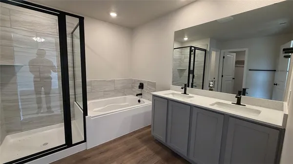 a bathroom with a tub sink and mirror