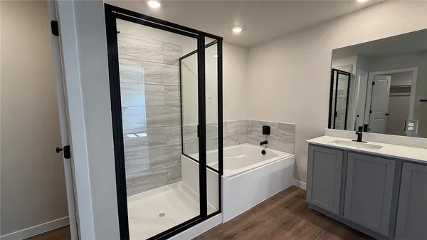 a bathroom with a tub sink and mirror