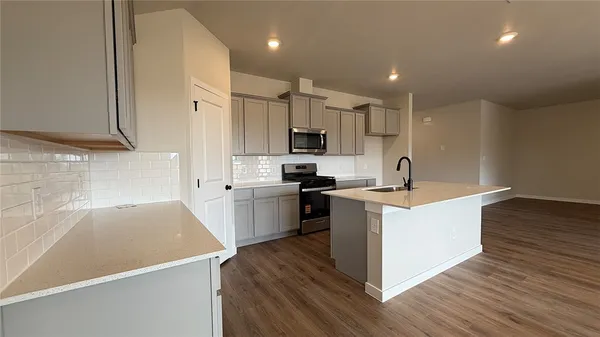 a kitchen with a sink a counter top space stainless steel appliances and cabinets