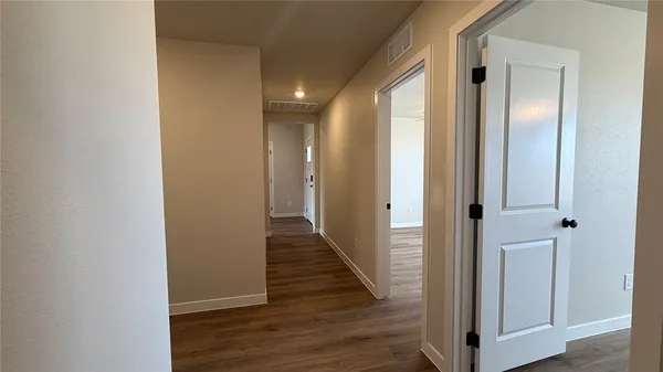 a view of a hallway with wooden floor