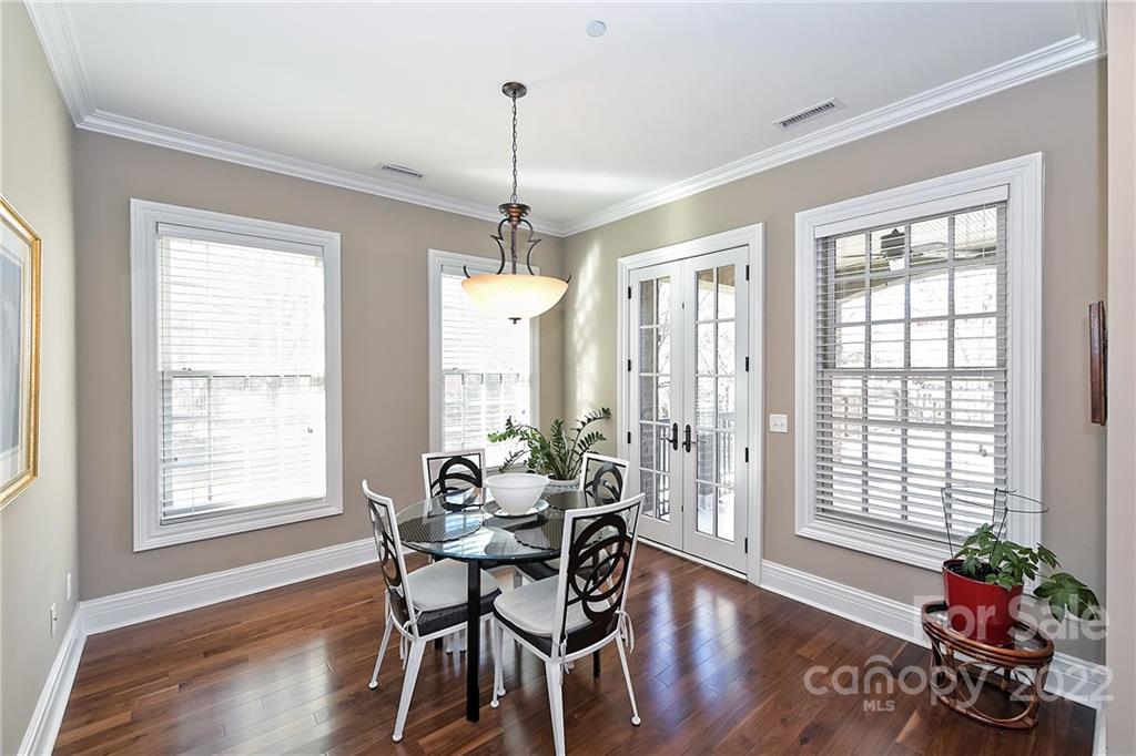 3240 Park Road Charlotte, NC 28209 - Photo 17 of 39 a dining room with wooden floor a chandelier a wooden table and chairs