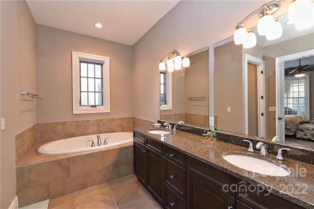 3240 Park Road Charlotte, NC 28209 - Photo 24 of 39 a bathroom with a granite countertop tub double vanity and a mirror