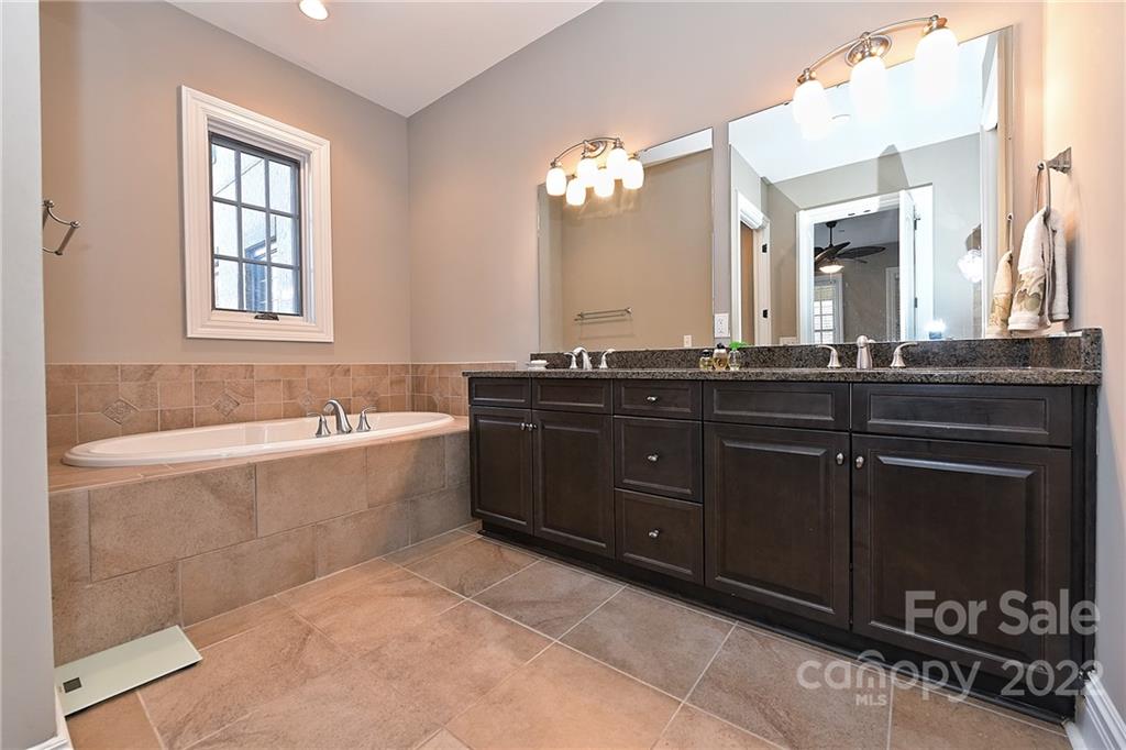 3240 Park Road Charlotte, NC 28209 - Photo 25 of 39 a spacious bathroom with a granite countertop double vanity sink a mirror and a bathtub