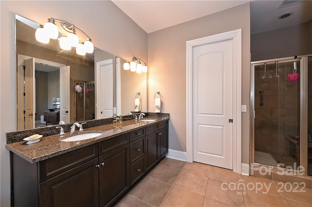 3240 Park Road Charlotte, NC 28209 - Photo 26 of 39 a bathroom with a granite countertop sink a mirror and a shower