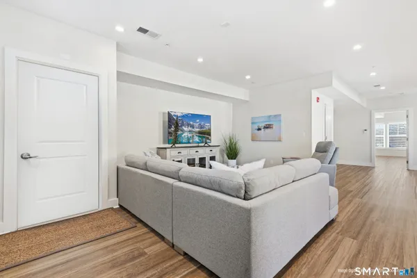 a living room with furniture and a wooden floor