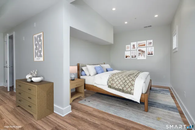 a bedroom with a bed and wooden floor