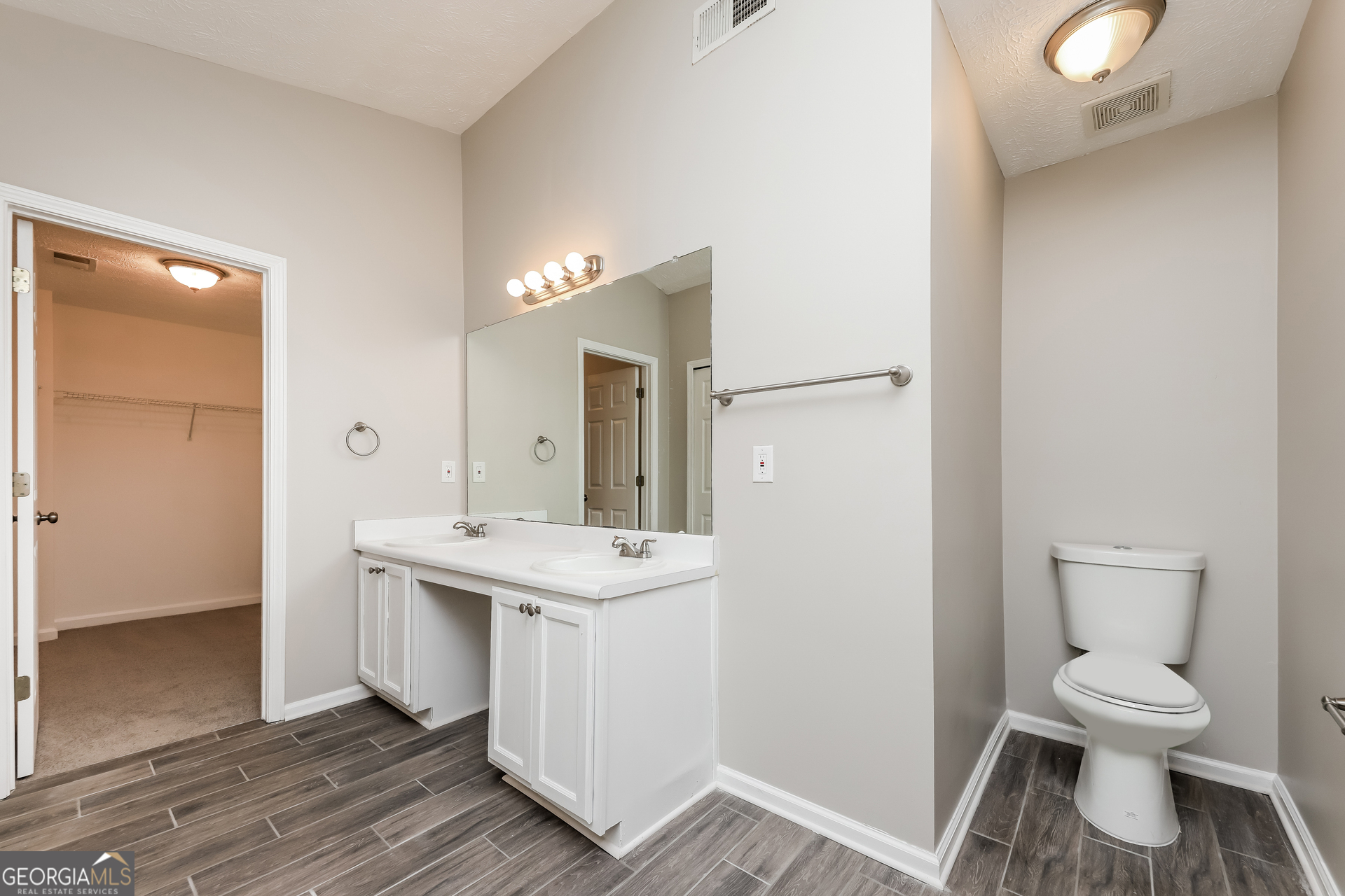 9945 Rivercliff Lane Villa Rica, GA 30180 - Photo 11 of 17 a spacious bathroom with a toilet sink and a mirror