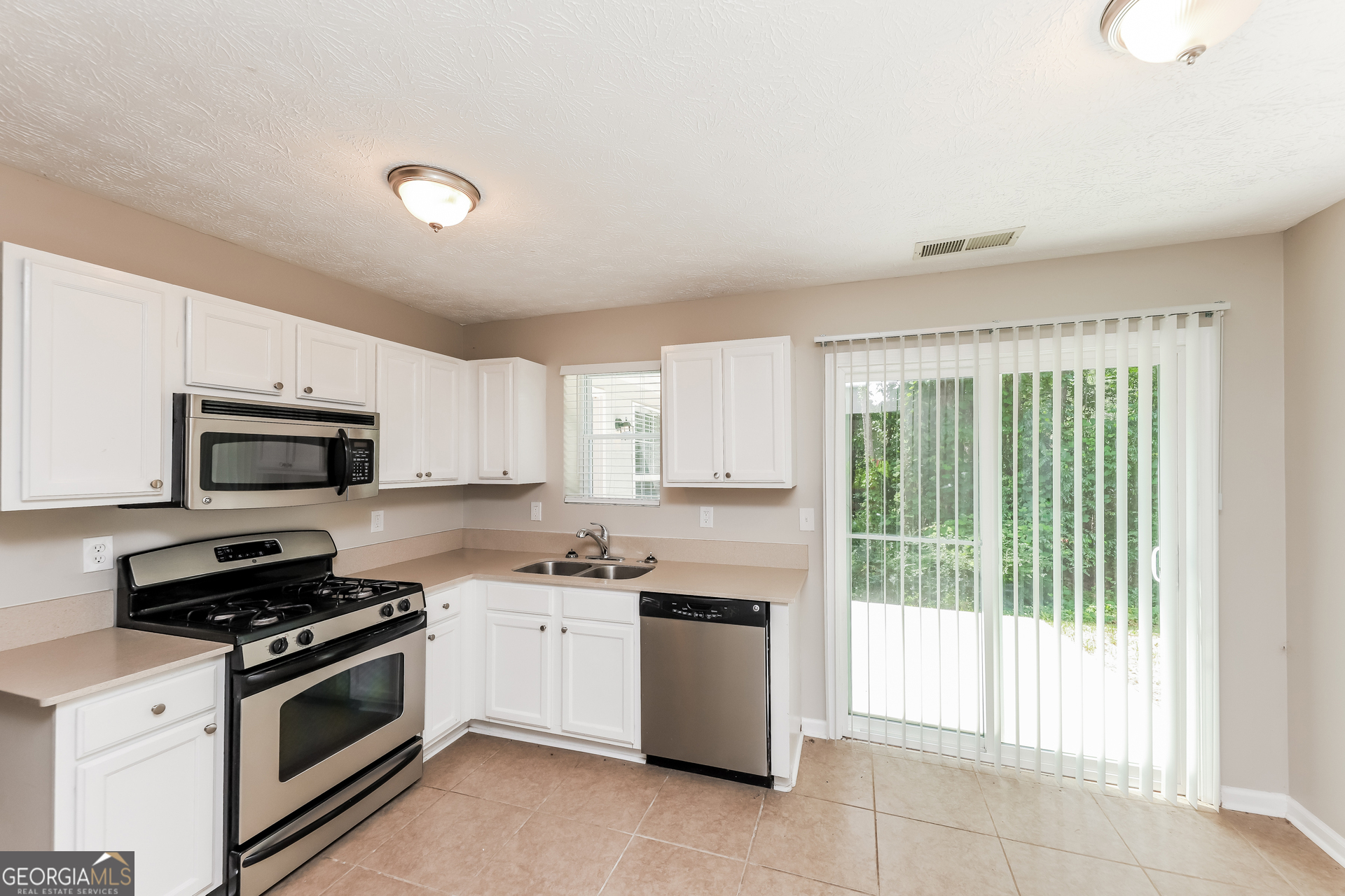 9945 Rivercliff Lane Villa Rica, GA 30180 - Photo 6 of 17 a kitchen with a stove a sink and a microwave