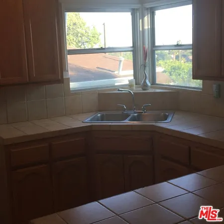 a kitchen with a sink cabinets and a large window