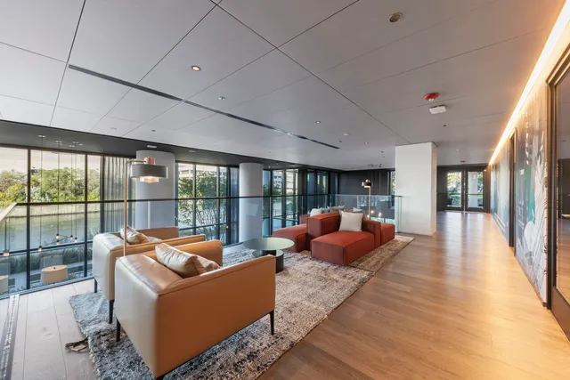 a living room with furniture fireplace and large windows