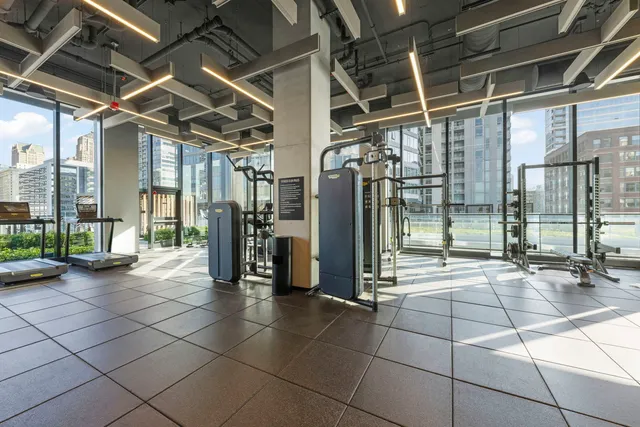 a room with gym equipment and wooden floor
