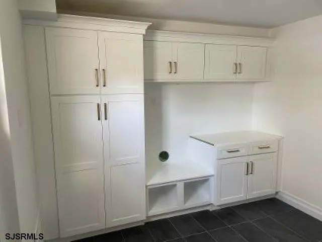 a kitchen with white cabinets and white appliances