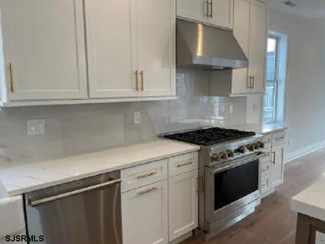a kitchen with white cabinets and a stove top oven