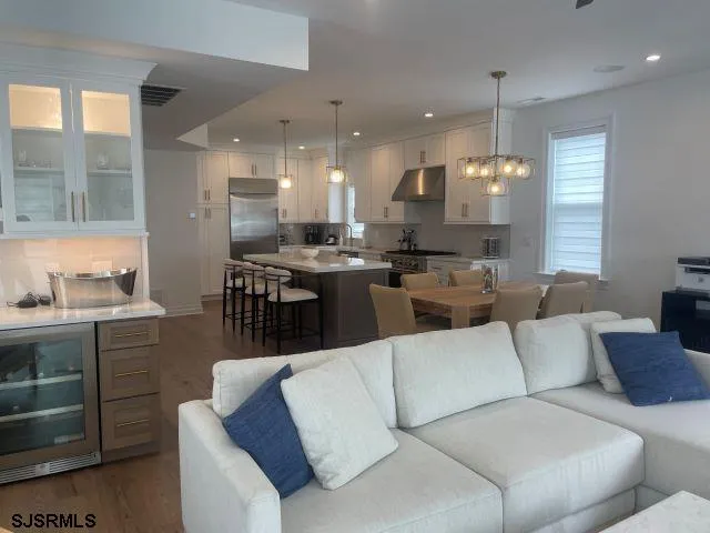 a living room with furniture kitchen view and a large window