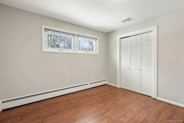 an empty room with wooden floor and window