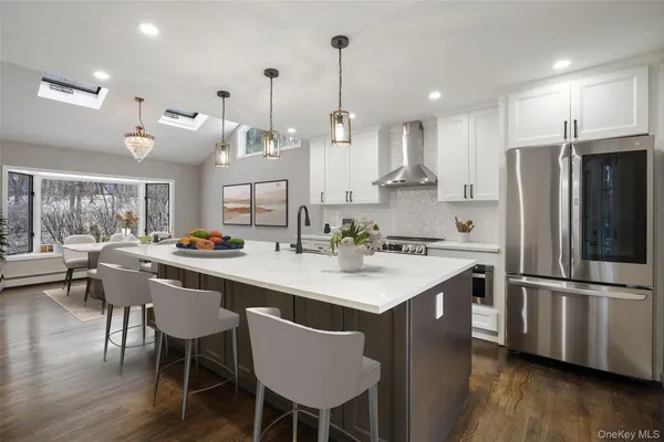 a kitchen with stainless steel appliances a dining table chairs stove and refrigerator