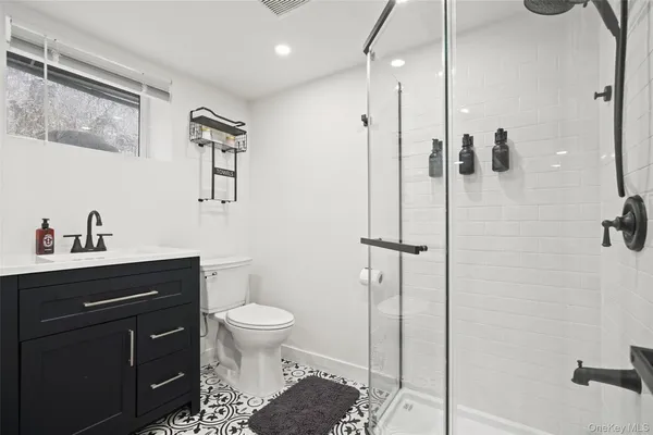 a bathroom with a granite countertop sink toilet and shower