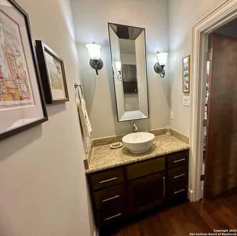 a bathroom with a granite countertop sink and mirror