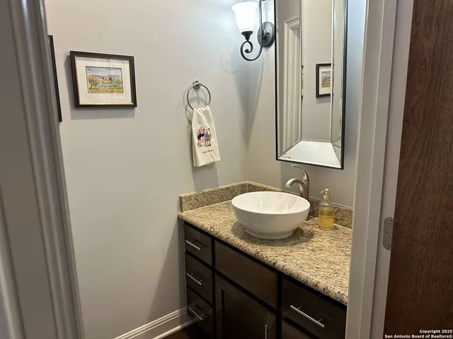 a bathroom with a granite countertop sink and a mirror