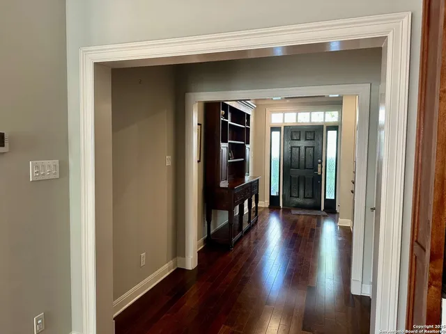 a view of a hallway with wooden floor and stairs