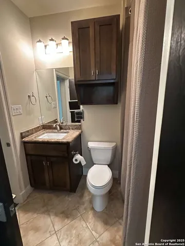 a bathroom with a toilet a sink and a mirror