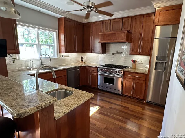 a kitchen with stainless steel appliances granite countertop a sink stove and refrigerator