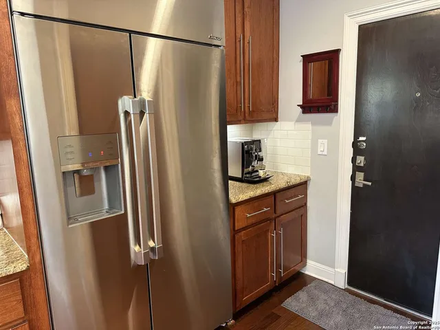 a kitchen with stainless steel appliances granite countertop a refrigerator and a sink