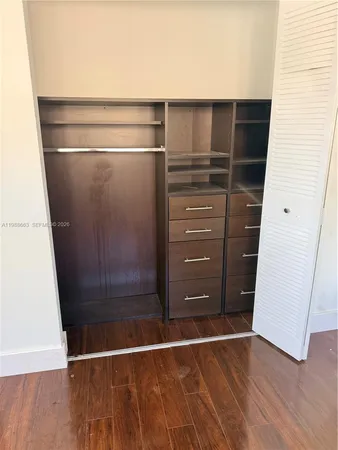 view of an empty room with wooden floor and a window