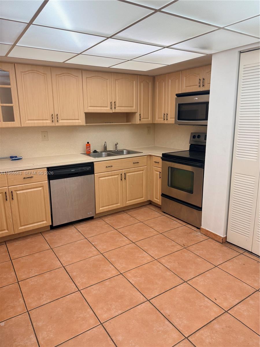 14343 Southwest 98th Terrace Miami, FL 33186 - Photo 7 of 16 a kitchen with stainless steel appliances granite countertop a stove a sink and a microwave