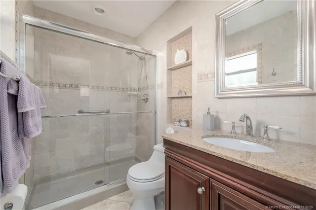 a bathroom with a granite countertop sink toilet and shower