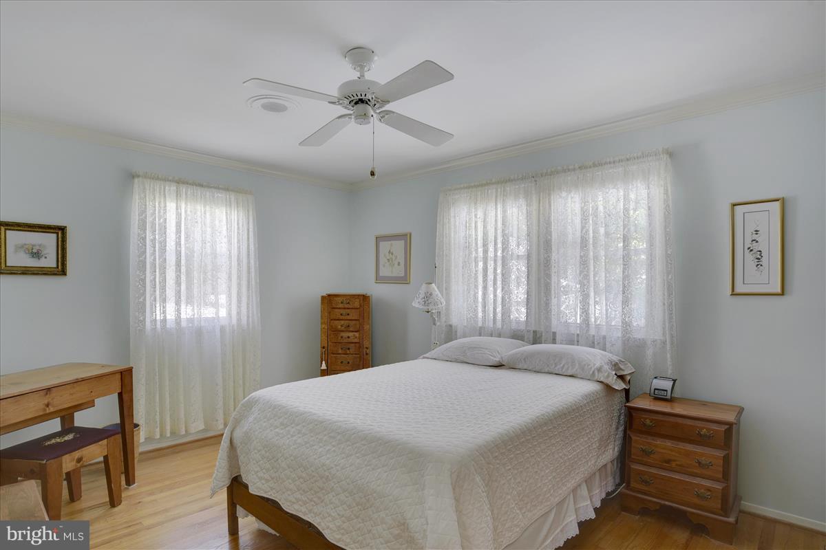 7516 Inzer Street Springfield, VA 22151 - Photo 13 of 30 a bedroom with a bed and a chandelier